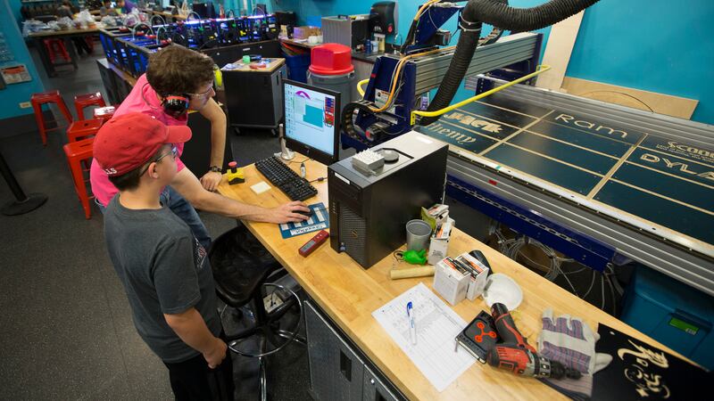 Two teens work on a “ShopBot” for computer-aided design and fabrication at Chicago’s Museum of Science and Industry.