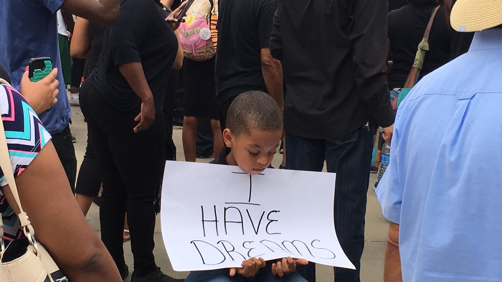 A youngster sits outside of the FedEx Forum in downtown Memphis, where Black Lives Matter protesters rallied July 10 before blocking the Interstate 40 bridge over the Mississippi River, shutting down traffic for four hours.
