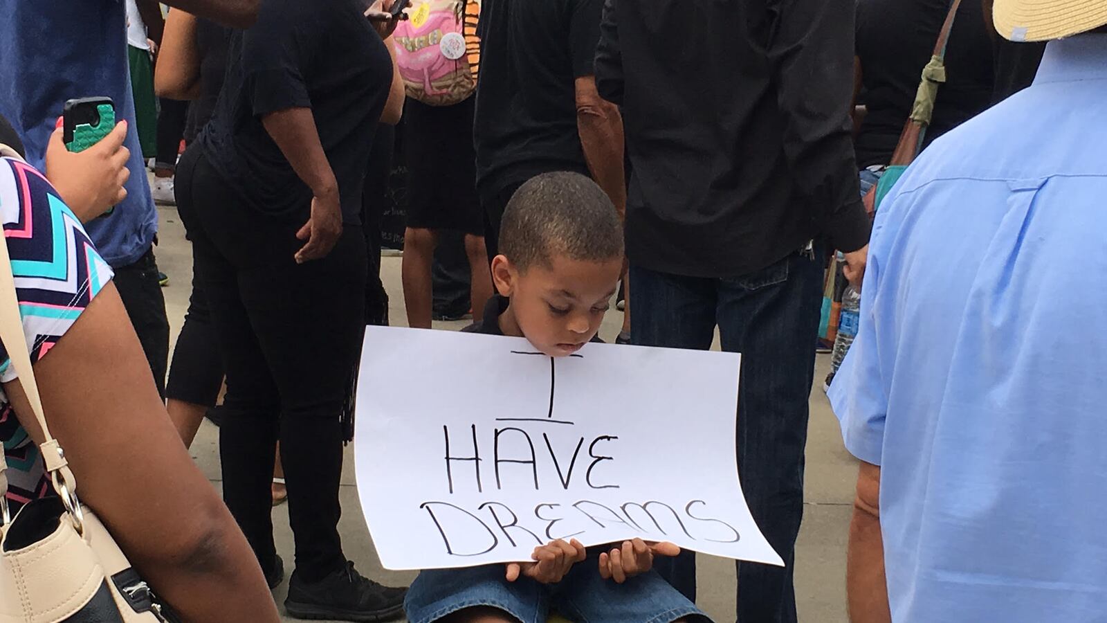 A youngster sits outside of the FedEx Forum in downtown Memphis, where Black Lives Matter protesters rallied July 10 before blocking the Interstate 40 bridge over the Mississippi River, shutting down traffic for four hours.