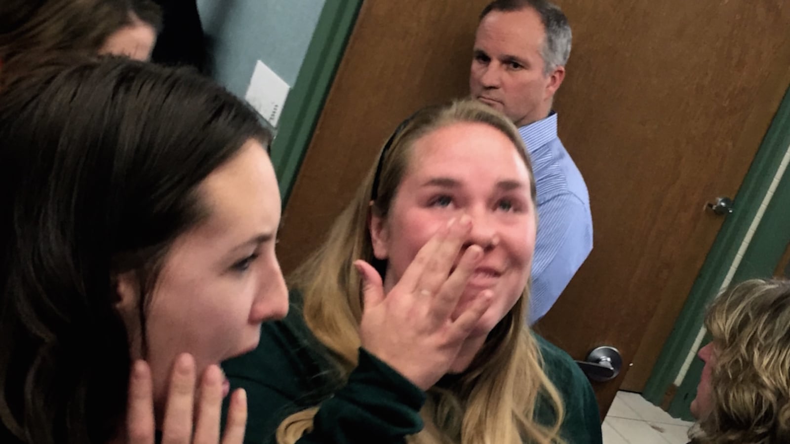 Members of AXL Academy charter school community, including Amber Malin, center, celebrated Tuesday night after the Aurora Public Schools Board of Education gave the financially struggling school a tentative lifeline.