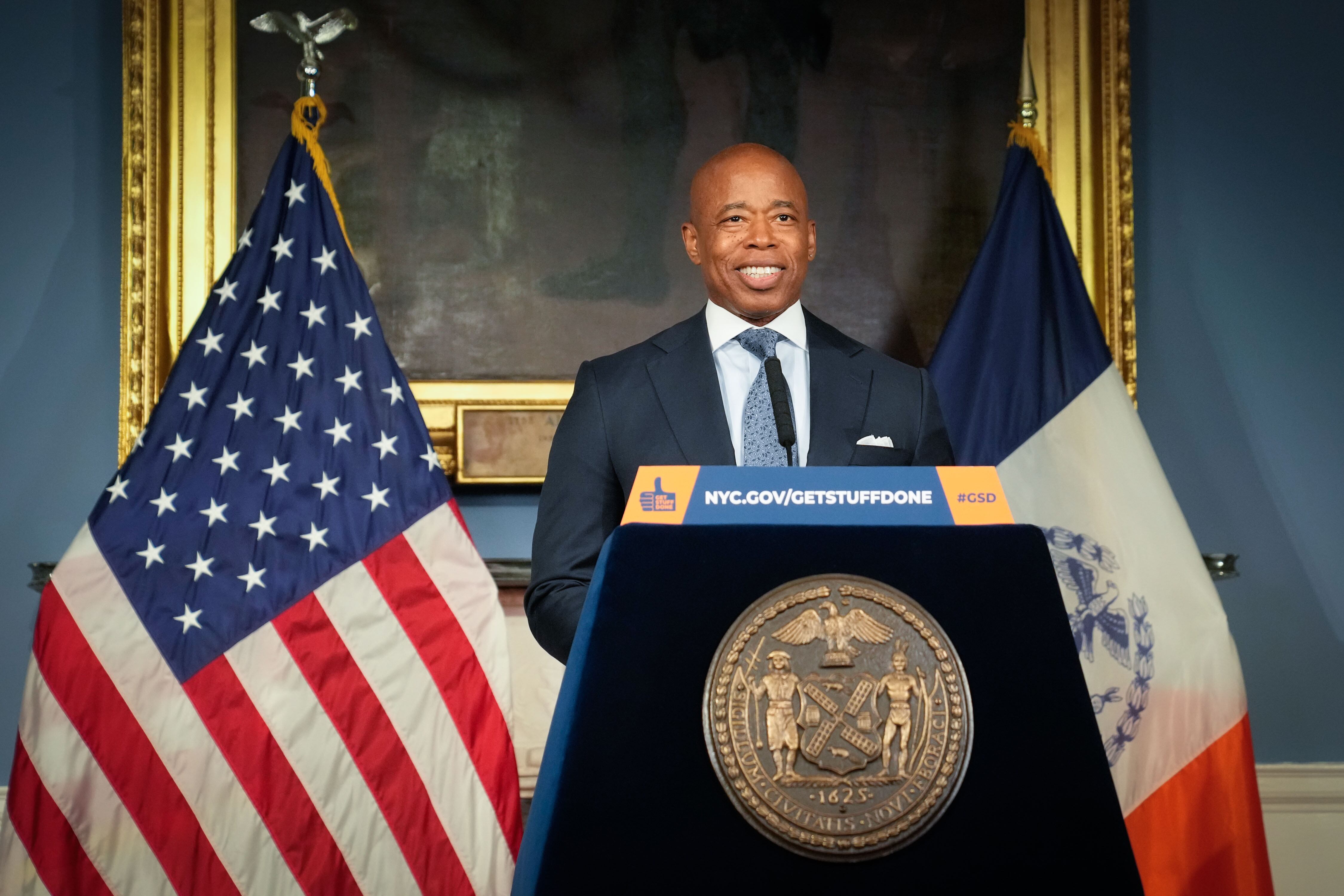 A man stands in front of a podium with a “Get Stuff Done” sign.