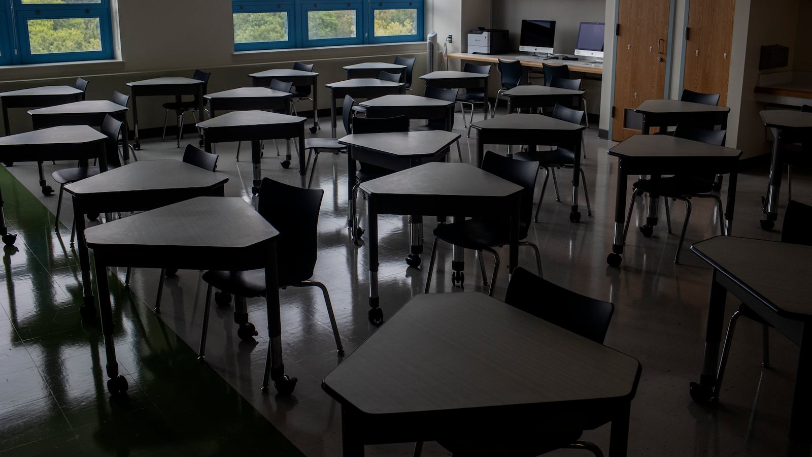 A classroom with many desks, but no students.