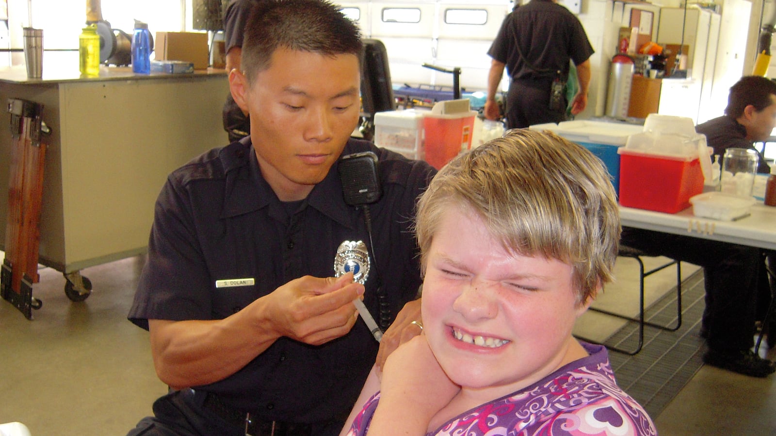 Kara Robinson, 11, received an immunization shot from Aurora fireman Sean Dolan at the Shots for Tots immunization clinic in 2011.