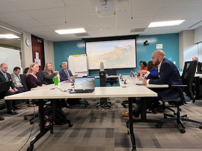 The Denver school board and superintendent sit around a conference table.