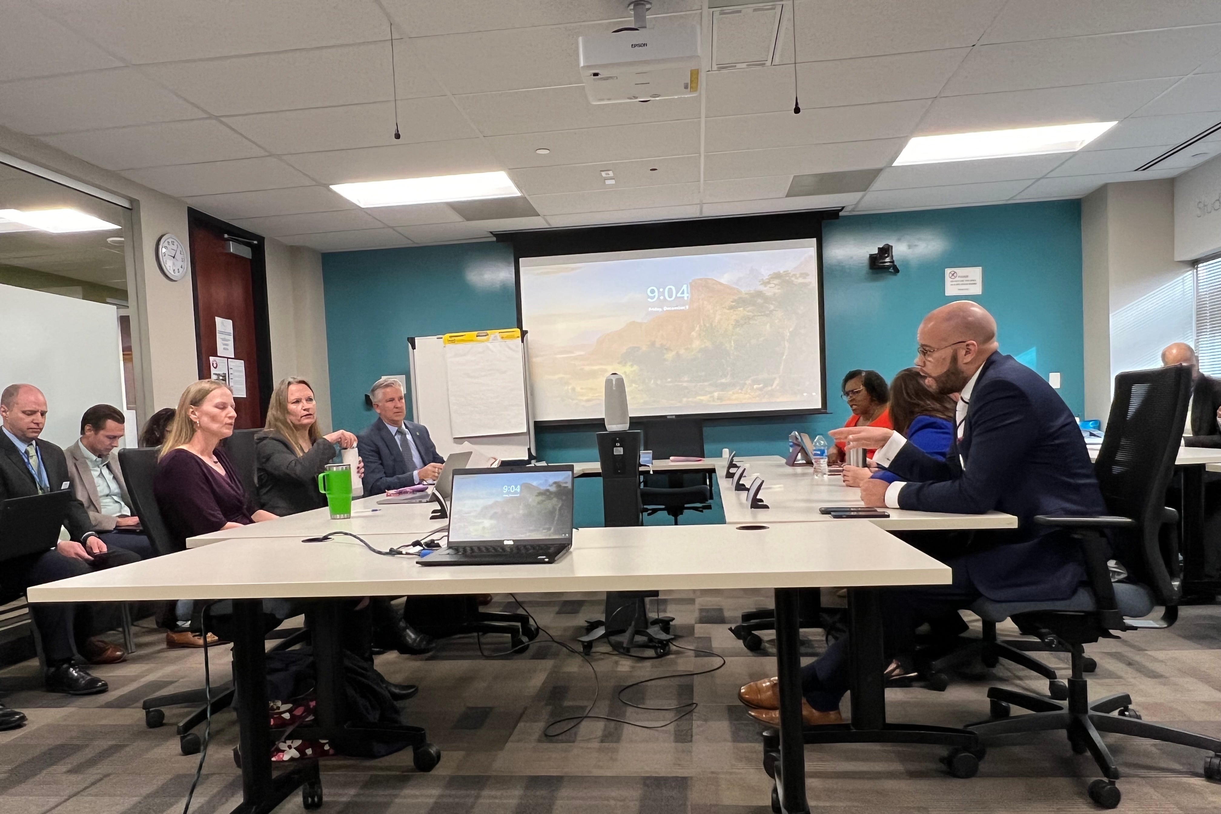 The Denver school board and superintendent sit around a conference table.