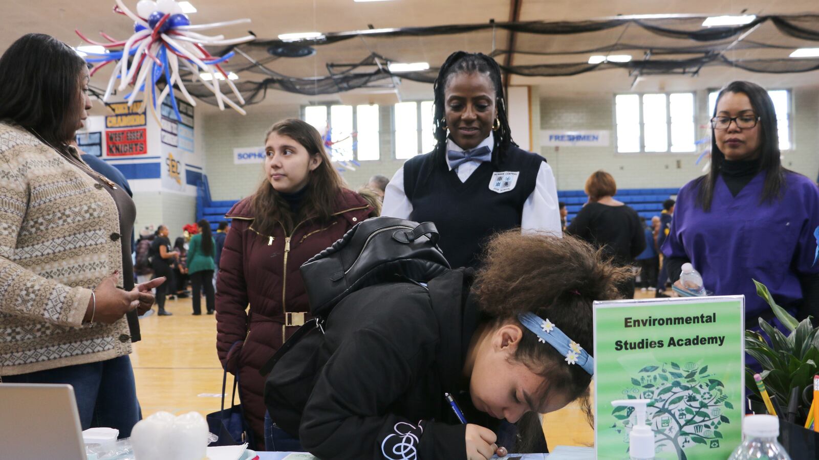 A student fills out an information sheet at Central High School's booth at the citywide school fair in December.