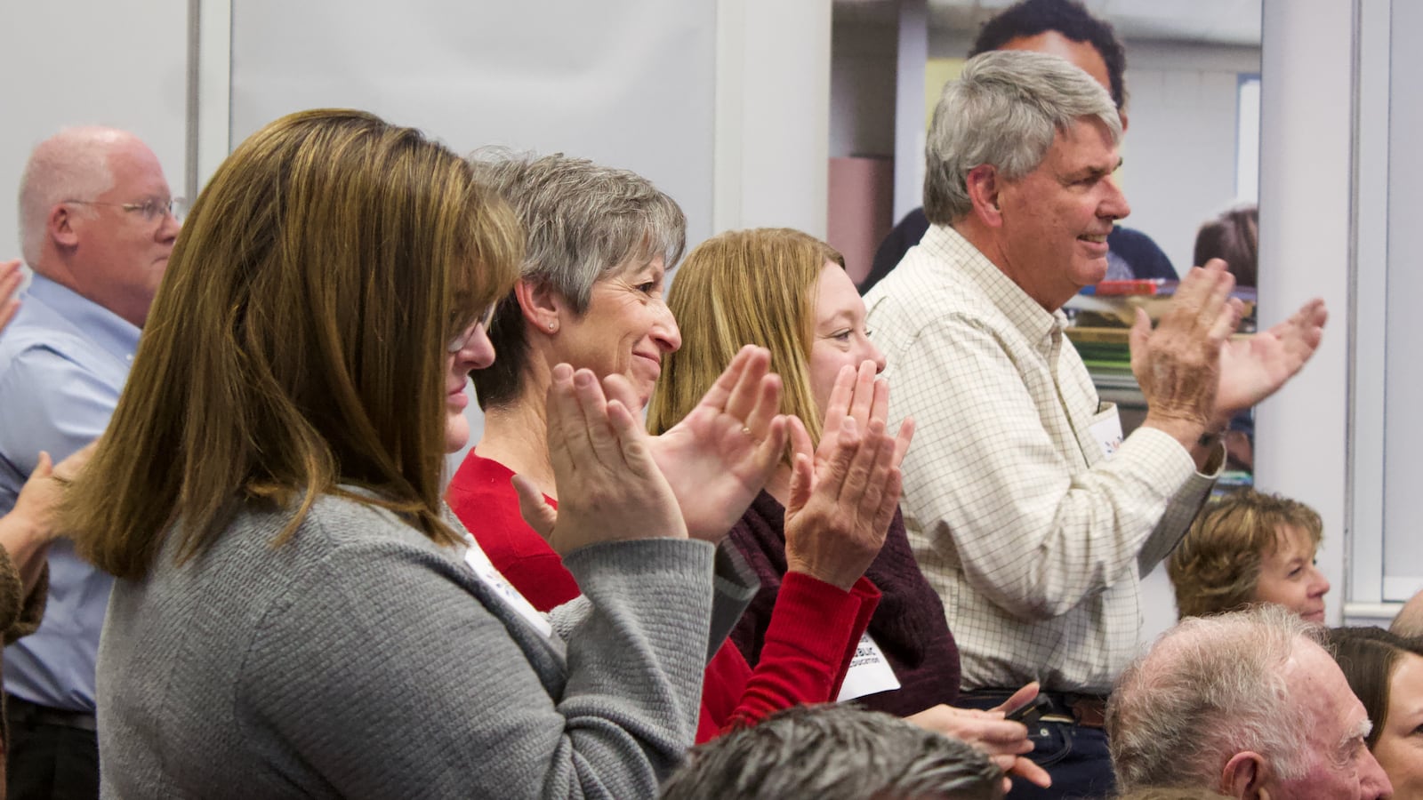 Cindy Barnard, second from left, applauds after the Douglas County school board voted to end the district's voucher program. Barnard is one of the original plaintiffs in the voucher court case. (Photo by Nic Garcia/Chalkbeat)