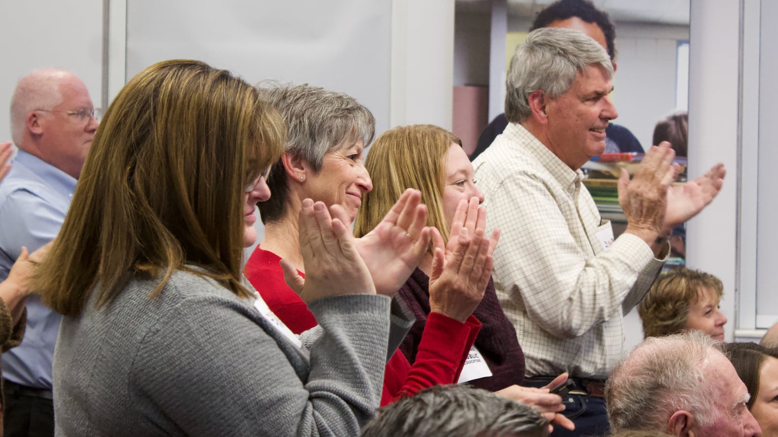 Cindy Barnard, second from left, applauds after the Douglas County school board voted to end the district's voucher program. Barnard is one of the original plaintiffs in the voucher court case. (Photo by Nic Garcia/Chalkbeat)