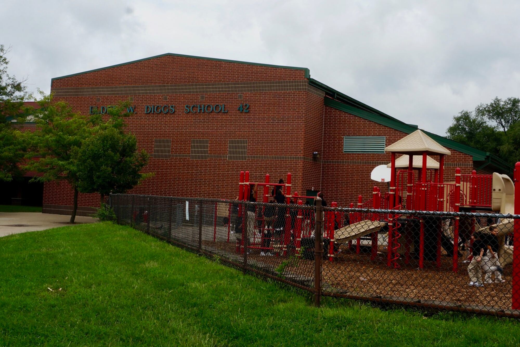 The brick exterior of Elder W. Diggs School 42 with a red playground in front.