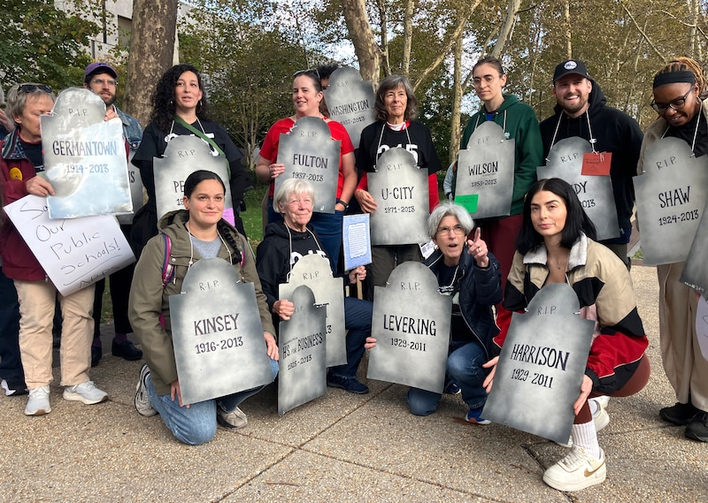 A group of people holds signs.