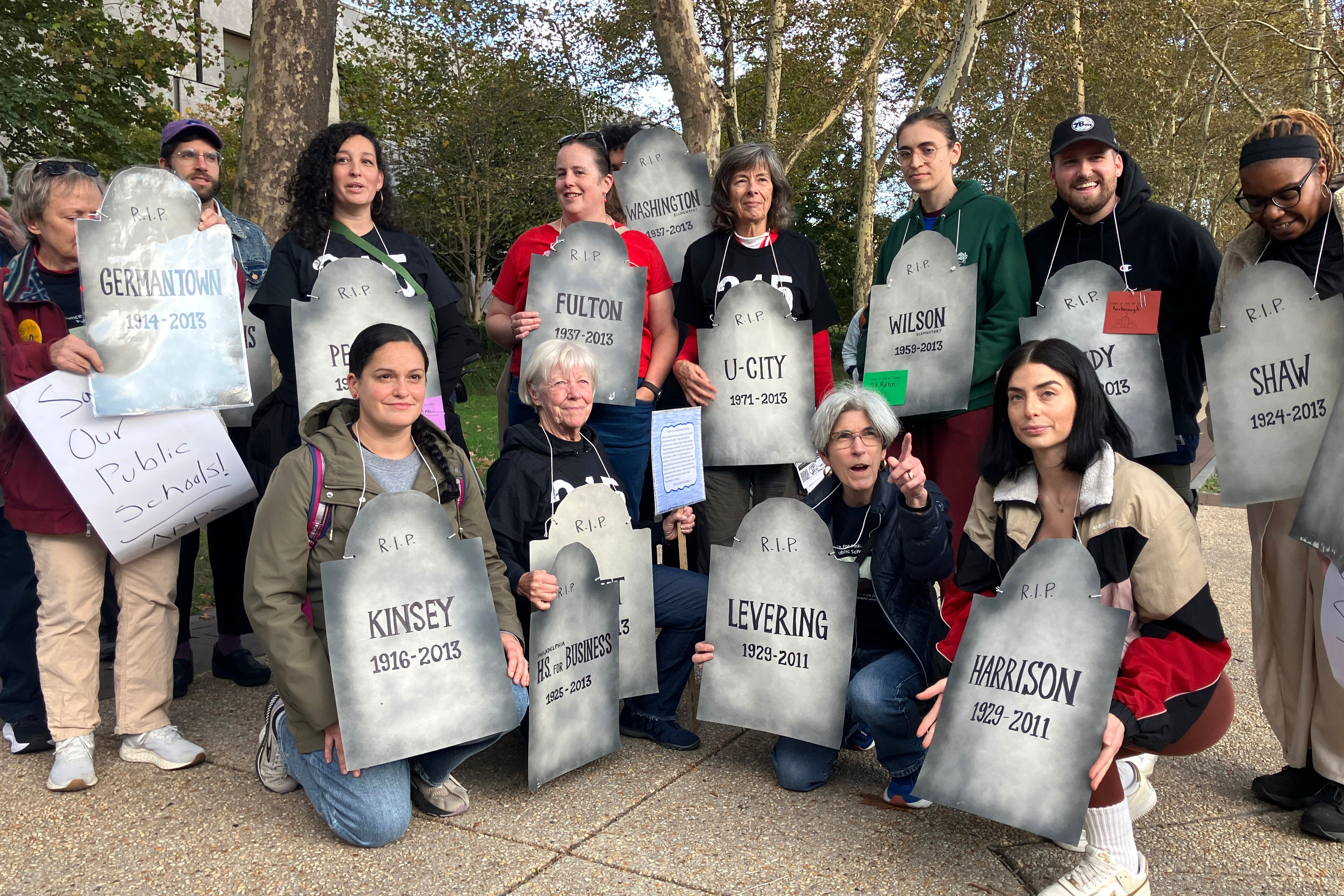 A group of people holds signs.