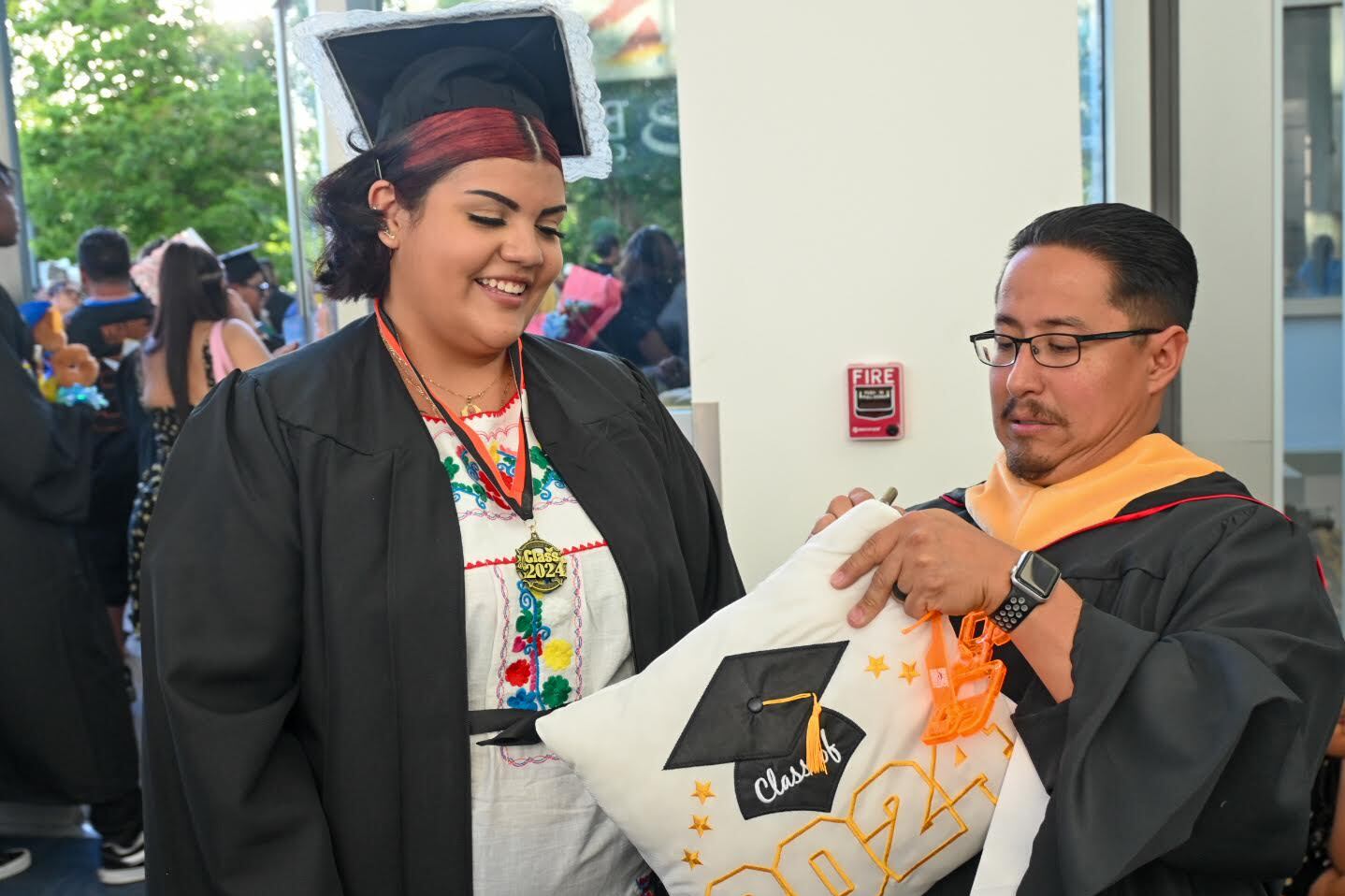 Denver Scholarship Foundation college adviser Federico Rangel signs a graduation pillow for Denver West High School senior Cassandra Torres on Tuesday. Rangel has helped students like Torres, 18, plan their college path.