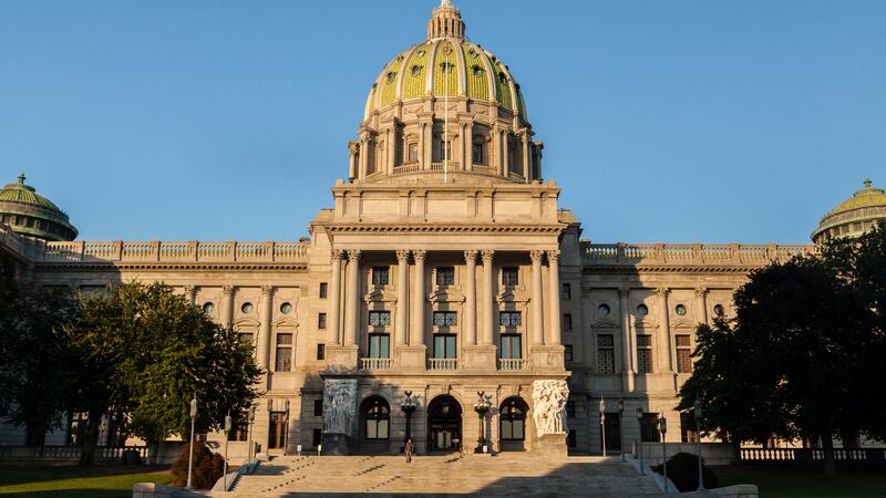 Sunlight shines on the Capitol dome in Harrisburg, Penn., with a blue sky in the background.