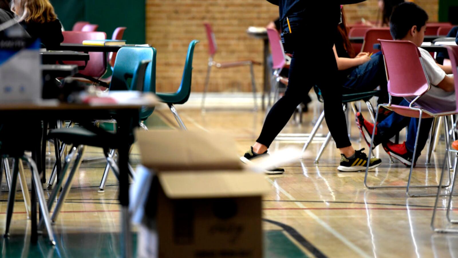 A teacher moves from table to table while teaching one of the two combined sixth grade classes in the gymnasium at Skinner Middle School during the first day of the Denver teacher strike.