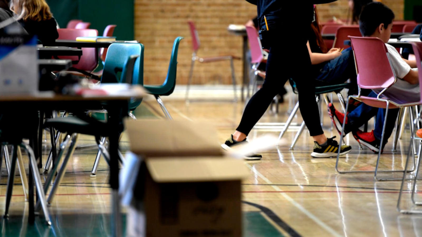 A teacher moves from table to table while teaching one of the two combined sixth grade classes in the gymnasium at Skinner Middle School during the first day of the Denver teacher strike.