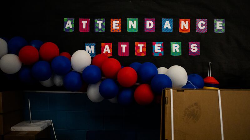 A garland of red, white, and blue balloons hangs in front of a sign that reads “Attendance matters.”