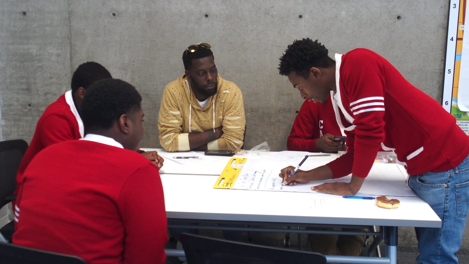 Memphis alternative school students work with local activist Keedran Franklin, in yellow, to brainstorm policy proposals to prevent other youth from being incarcerated. At the top of the list was mentoring and jobs. Just under that was a call to eliminate suspensions and expulsions and replace with fostering better relationships between teachers and students.