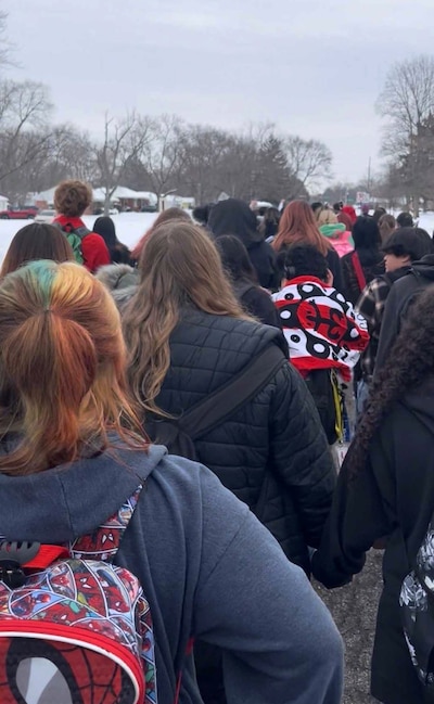 A photograph of a line of students outside on a cloudy day.