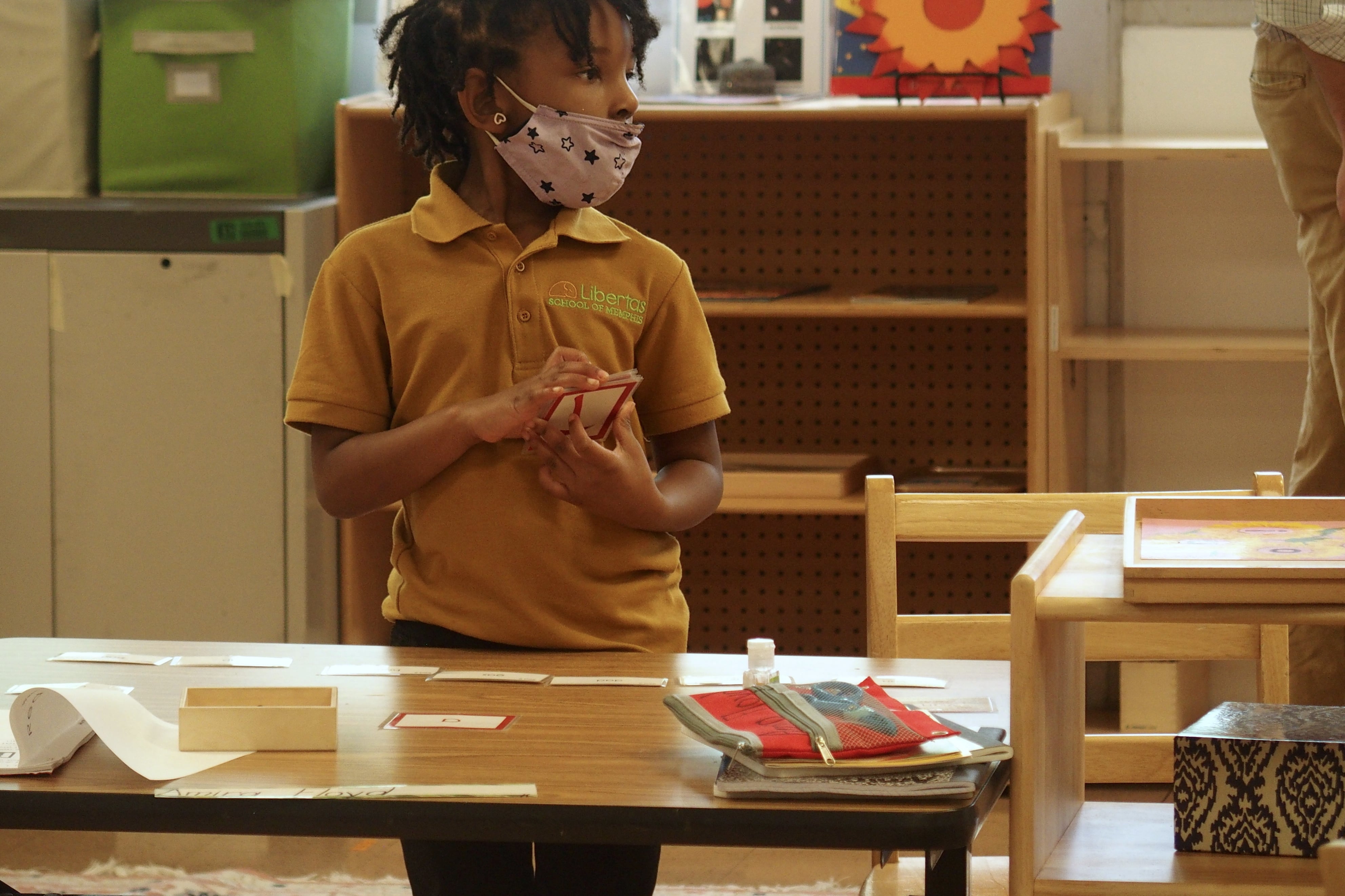 An elementary school student in class wearing a mask