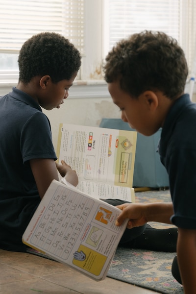 Two young boys look at books.