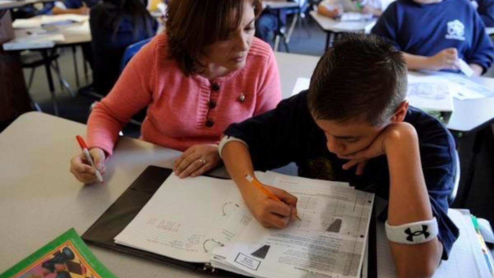Middle school math teacher Eliana Moore, left, gives Armando Flynn, 13, some extra attention to help with a lesson in algebra.