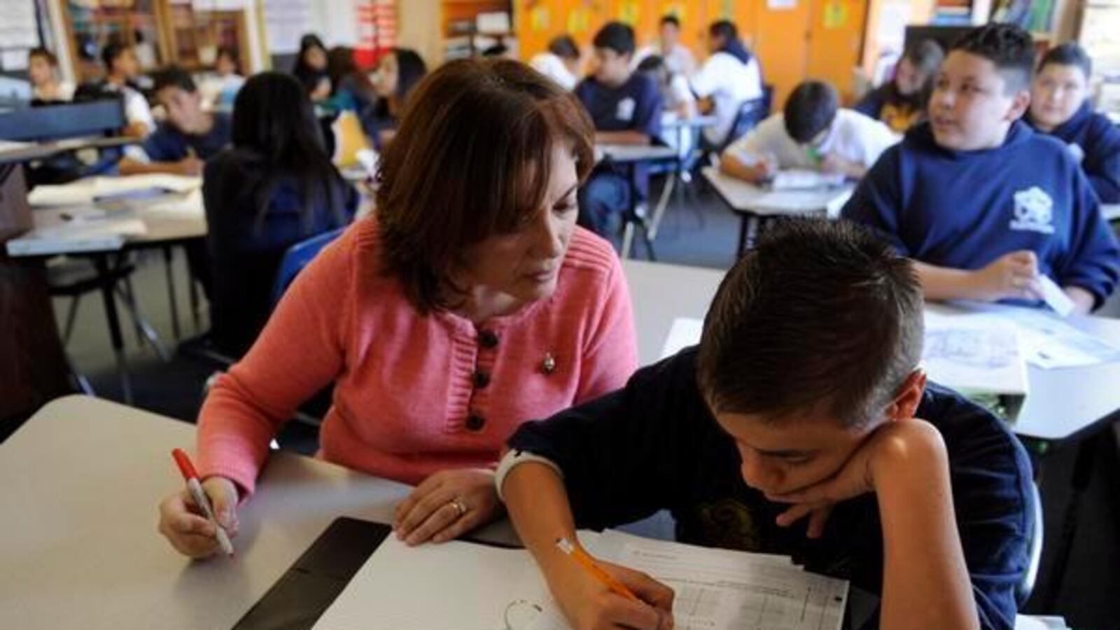 Middle school math teacher Eliana Moore, left, gives Armando Flynn, 13, some extra attention to help with a lesson in algebra.