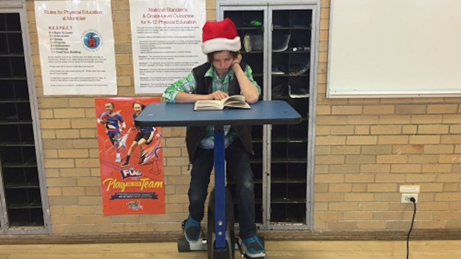 Fifth-grader Miles Dwyer reads at a pedal desk on loan to Montclair from a South Carolina company that makes youth fitness equipment.