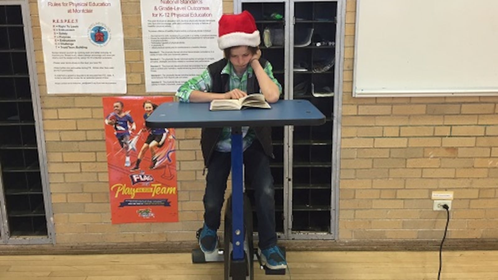 Fifth-grader Miles Dwyer reads at a pedal desk on loan to Montclair from a South Carolina company that makes youth fitness equipment.