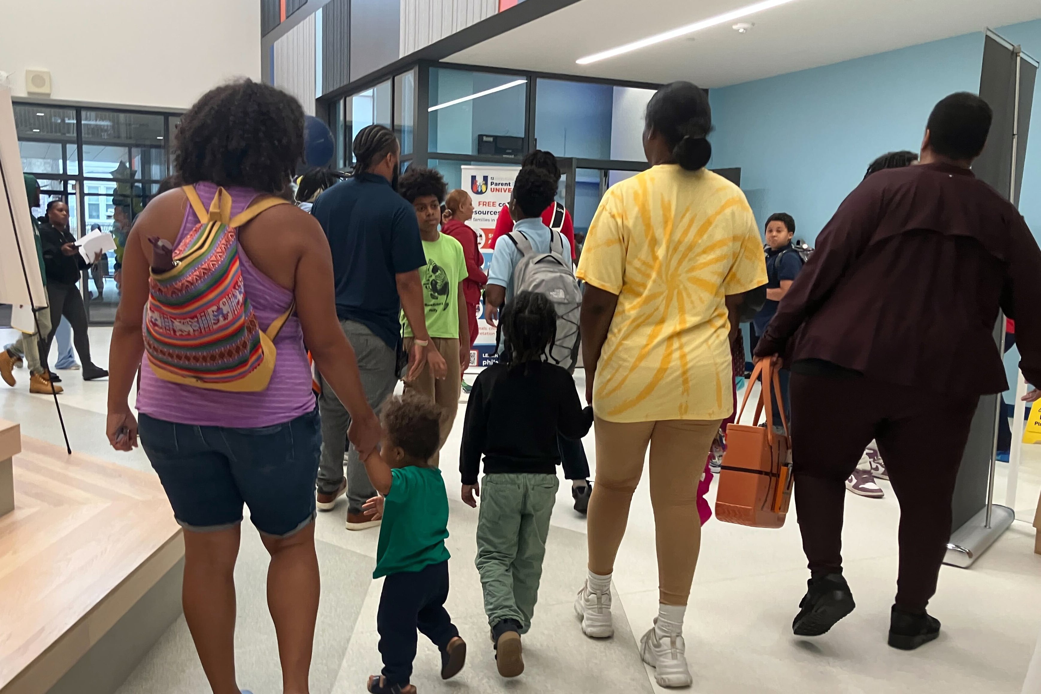 A photo of people walking inside of a school.