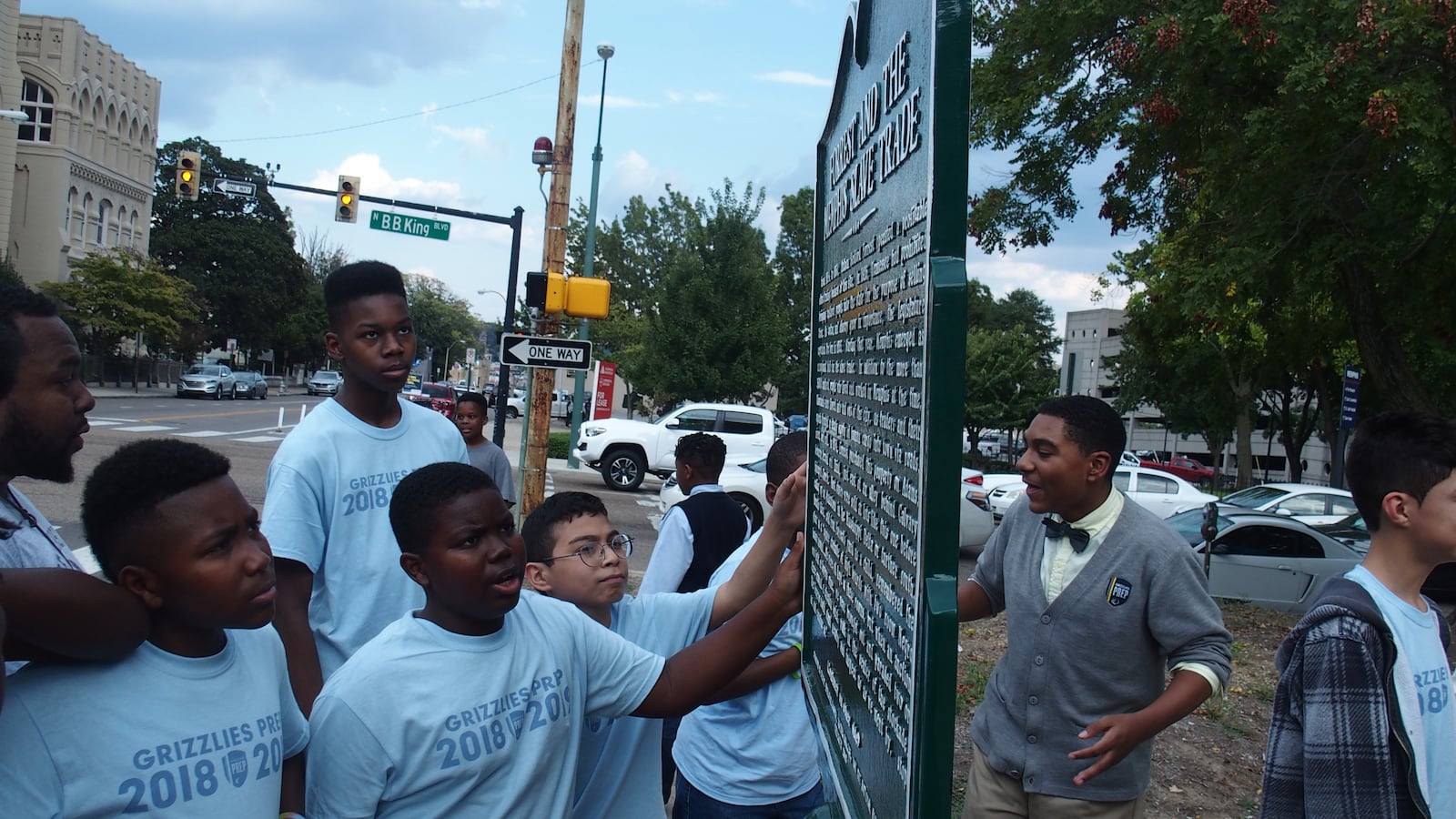 Students at Memphis Grizzlies Preparatory Charter School examine a historical marker meant to share a more complete story of Nathan Bedford Forrest, a Confederate general, slave trader, and early leader of the Ku Klux Klan.
