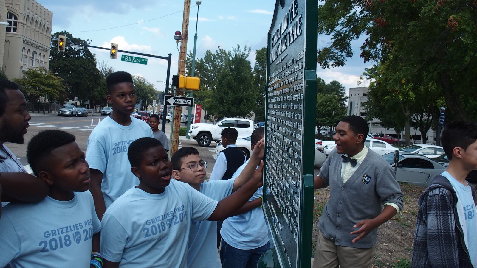 Students at Memphis Grizzlies Preparatory Charter School examine a historical marker meant to share a more complete story of Nathan Bedford Forrest, a Confederate general, slave trader, and early leader of the Ku Klux Klan.