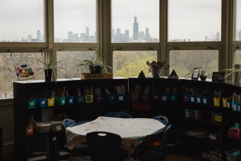 A photograph of a view of the Chicago skyline in the background of an empty classroom.