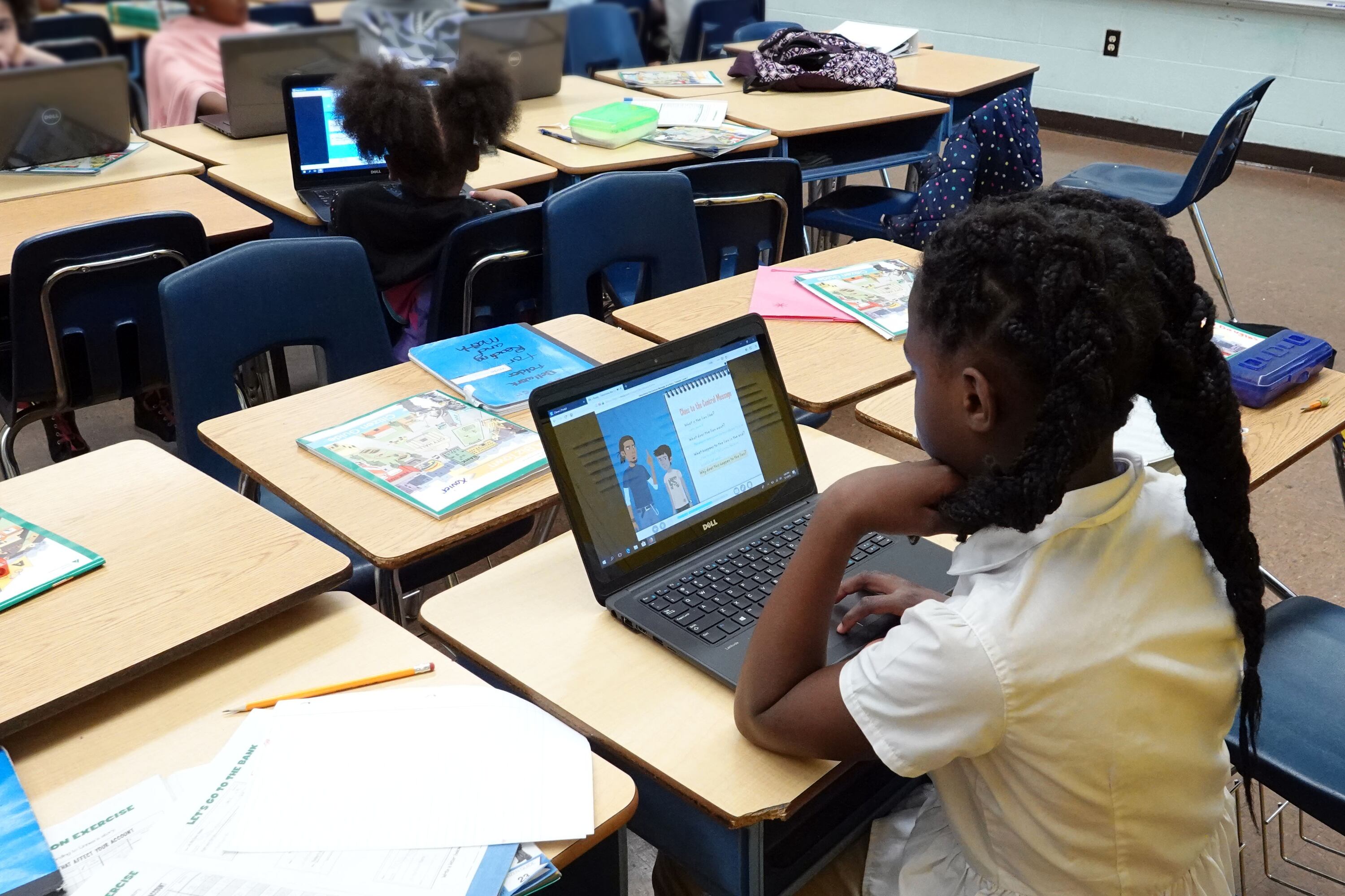 A students works on a laptop computer in a classroom