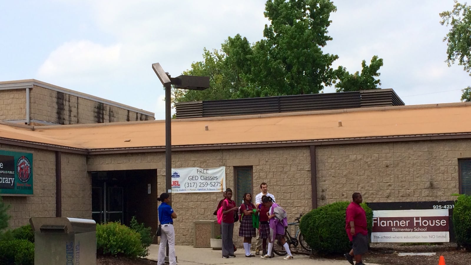 Students stand outside of Flanner House Elementary charter school in August as their parents learn about the schools impending closure in a private meeting. The school, which closed Sept. 11, was accused of cheating on the state ISTEP exam by the mayor's office and the state.