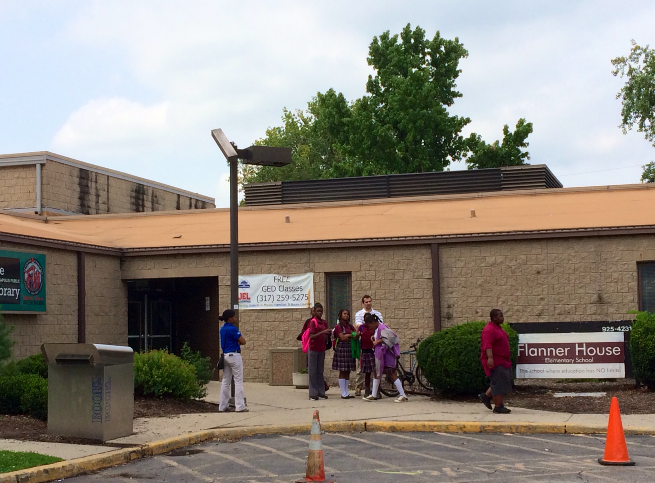 Students stand outside of Flanner House Elementary charter school in August as their parents learn about the schools impending closure in a private meeting. The school, which closed Sept. 11, was accused of cheating on the state ISTEP exam by the mayor's office and the state.