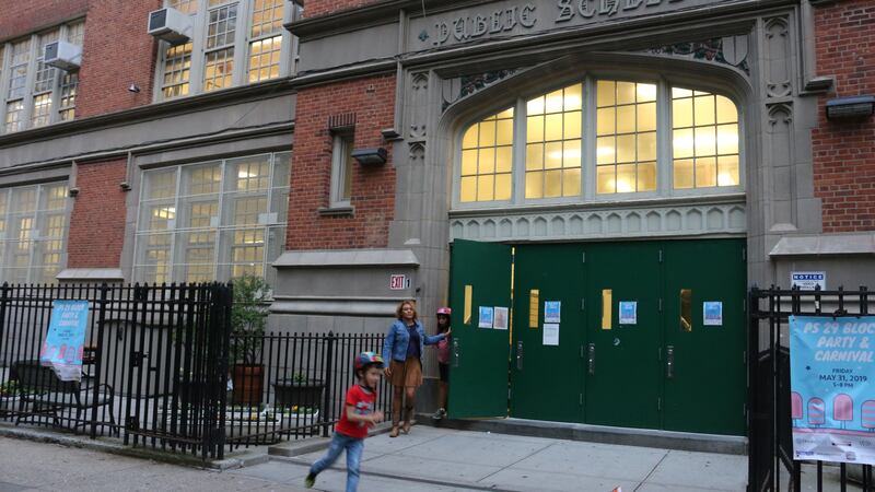 The outside front doors of P.S. 29 in Cobble Hill are pictured, with a child out front. The school is one of seven schools that could be affected by sweeping attendance zone changes proposed for Brooklyn’s District 15.