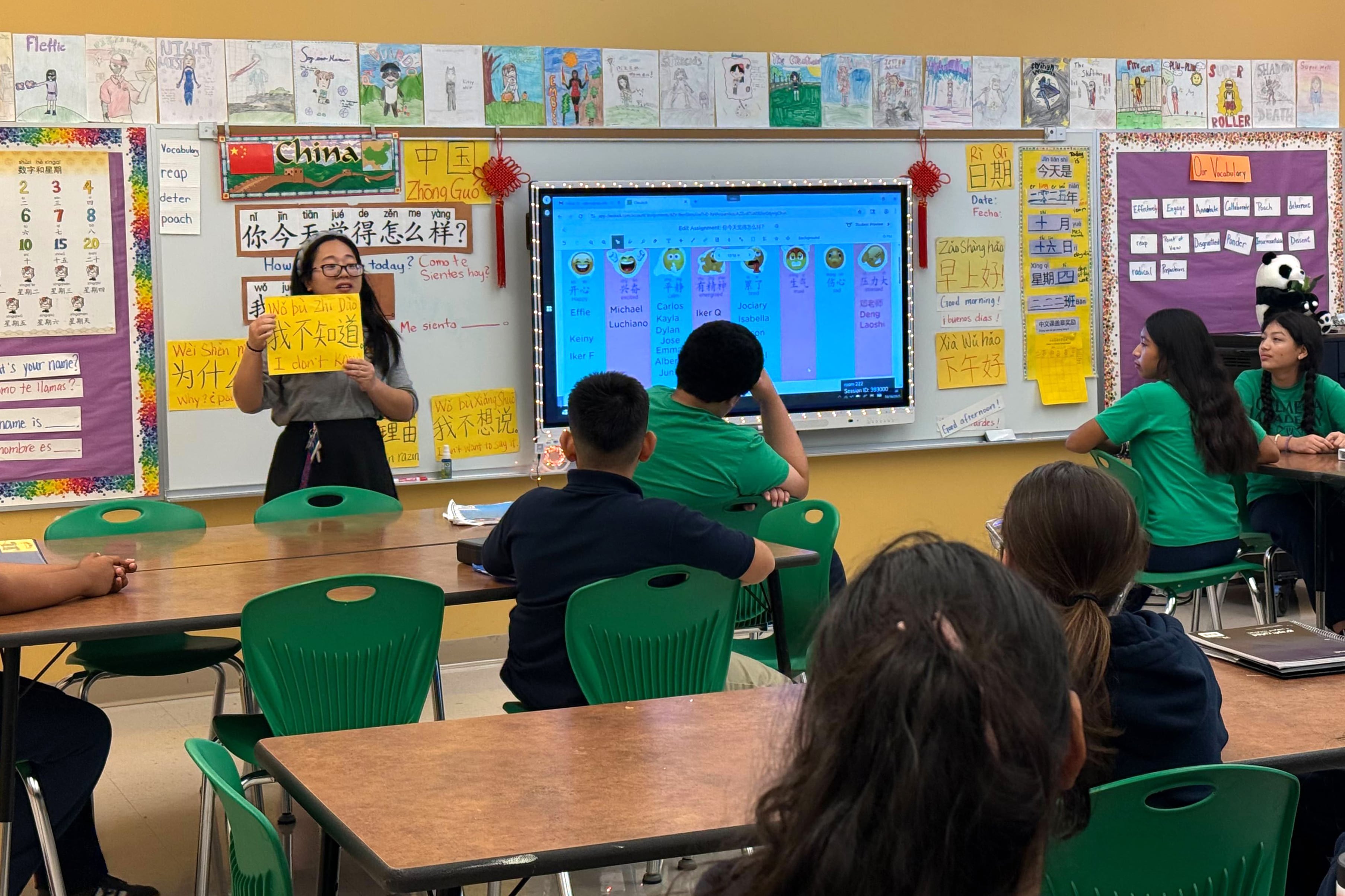 A woman in glasses holds a sign with Chinese letters.