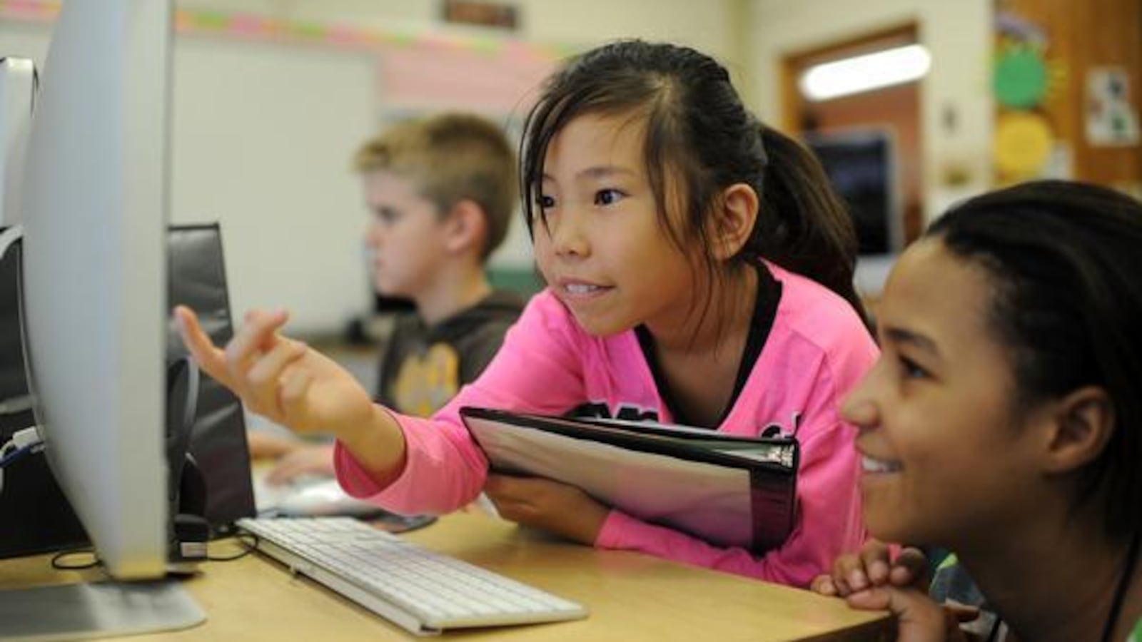 Lucky Bayar, 8, left, and Tanya Pezin, 11, check their computer project at Ellis Elementary School.