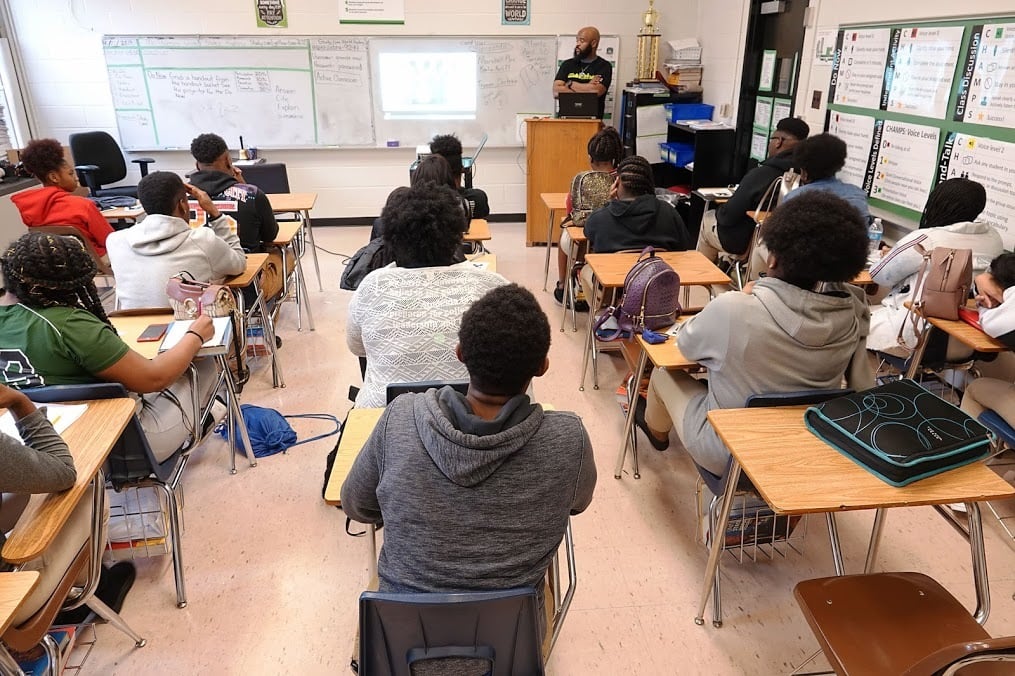 A group of students sit at desks in a classroom.