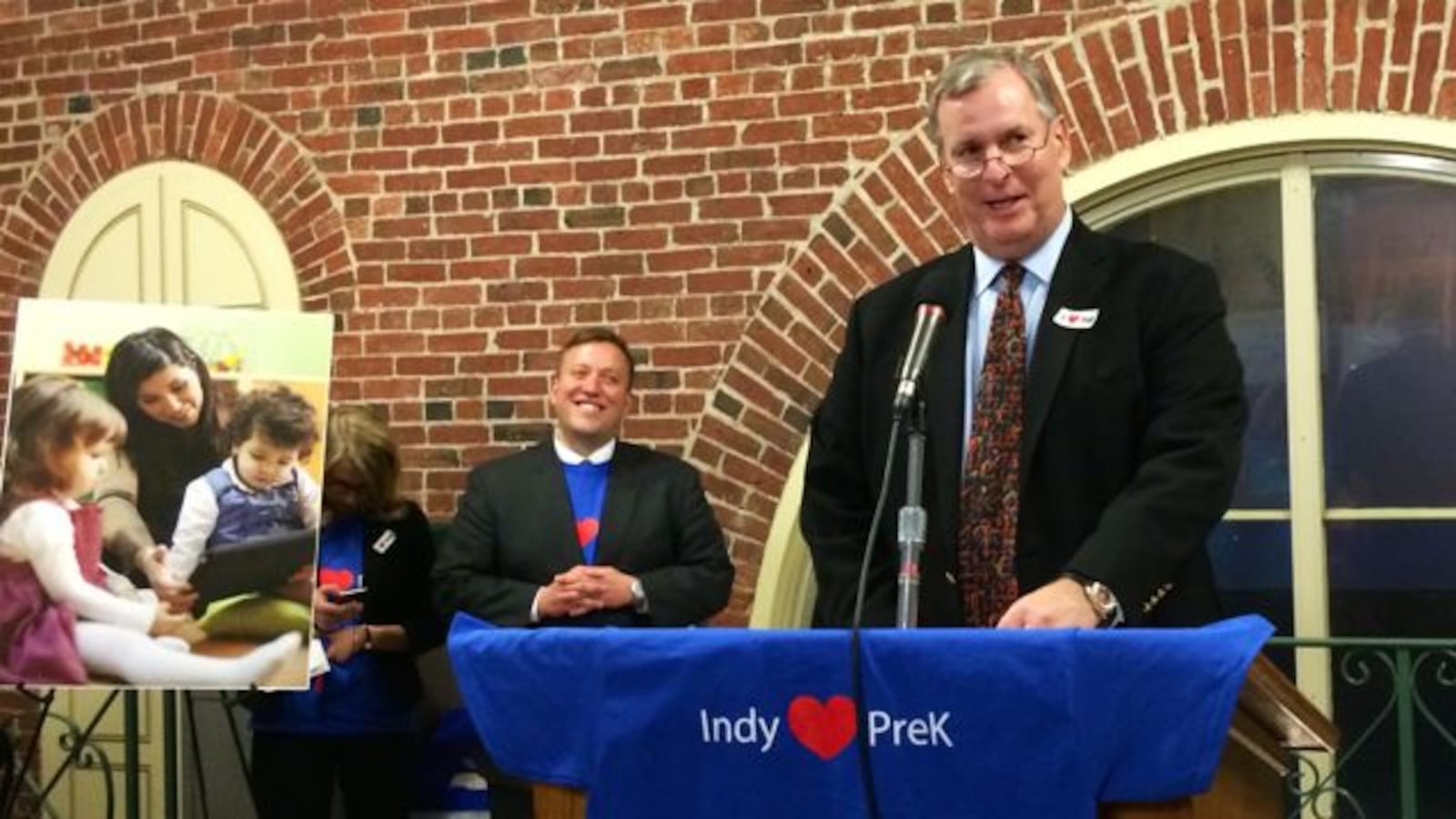 Indianapolis Deputy Mayor Jason Kloth looks on while Mayor Greg Ballard speaks at a December 2014 rally in support of his proposed preschool tuition program.