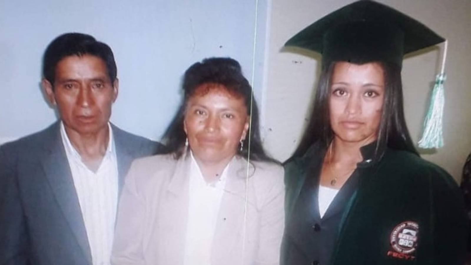 A family at a college graduation ceremony // Una familia en una ceremonia de graduación universitaria.