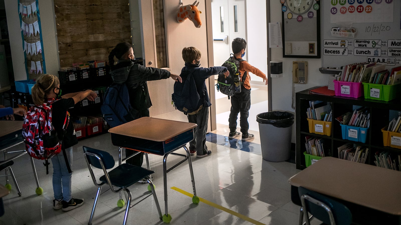 A kindergarten class socially distances while preparing to leave their classroom at Stark Elementary School on October 21, 2020 in Stamford, Connecticut. Stamford Public Schools is continuing the fall semester with a hybrid model of in-class and distance learning, occasionally quarantining individual classes when a student or faculty member tests positive for COVID-19. (Photo by John Moore/Getty Images)