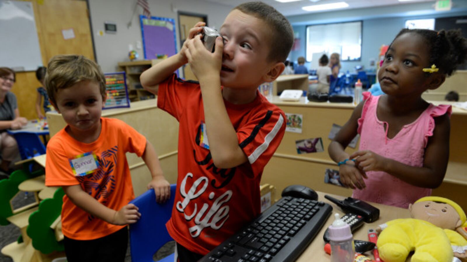 Max Gonzalez, 4, center, Gunnar Riley, 4, left, and Brooklyn Jones, 4, take turns looking through a camera as they spend part of their first week getting to know their new friends at Beck Preschool inside the Beck Recreation Center on August 29, 2017 in Aurora, Colorado. (Photo by Kathryn Scott/The Denver Post)