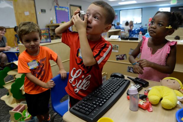 Max Gonzalez, 4, center, Gunnar Riley, 4, left, and Brooklyn Jones, 4, take turns looking through a camera as they spend part of their first week getting to know their new friends at Beck Preschool inside the Beck Recreation Center on August 29, 2017 in Aurora, Colorado. (Photo by Kathryn Scott/The Denver Post)