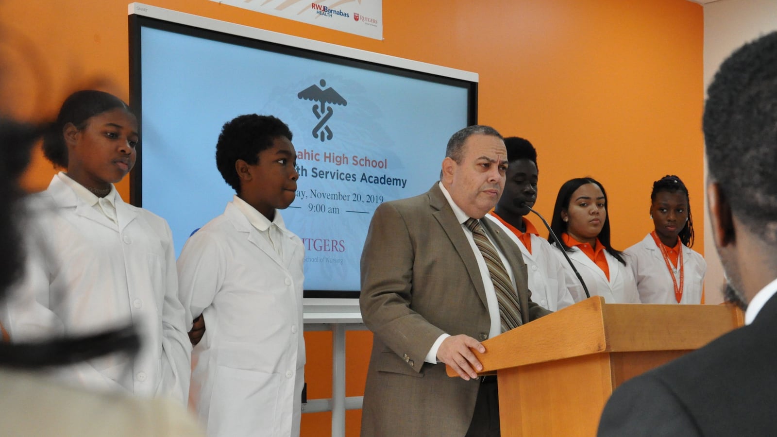 Flanked by Weequahic High School students, Newark superintendent Roger León announces a new allied health career academy.