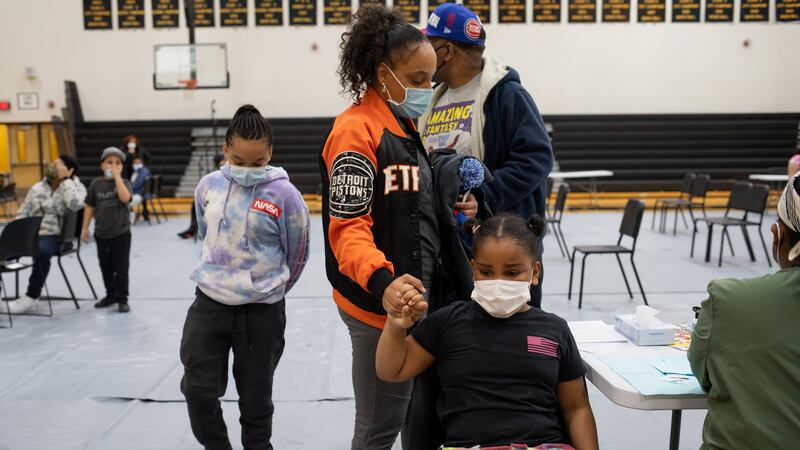 A girl holds her mother’s hand as she gets ready to receive her first dose of the Pfizer-BioNTech coronavirus disease (COVID-19) vaccine during a pediatric vaccine clinic at Martin Luther King, Jr. Senior High School in Detroit, Michigan,