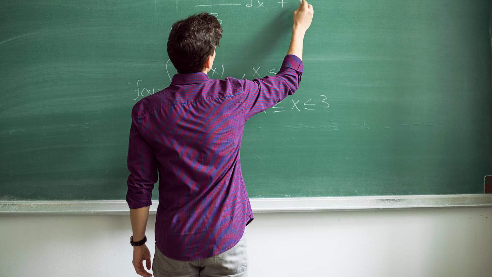 Student writing on blackboard