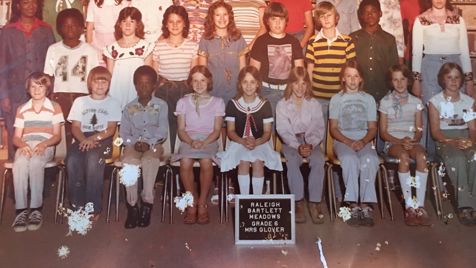 The integrated sixth grade class at Raleigh Bartlett-Meadows in the mid-1970s. Jacqueline Hill-Ferby, who was bused to the school from her home 45 minutes away, is standing on the far left, wearing green, behind one of her first professional role models and teacher, Mrs. Glover. Hill-Ferby, who became a teacher herself, says busing was a positive experience for her.