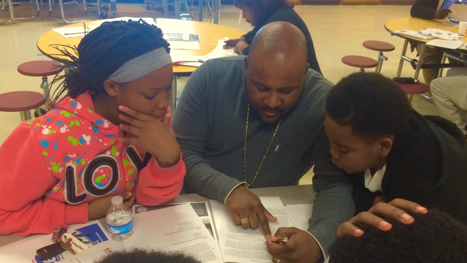 Shamaine Walls reviews TNReady practice questions with his niece Angelica Walls and nephew Mario Taylor at a TNReady information event sponsored in Memphis by the Tennessee Education Association.