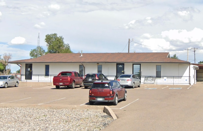 A screen grab of a google maps street view of a school building on a sunny day with cars parked in the parking lot out front.